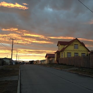 A street in Porvenir, Tierra del Fuego, beneath a vivid sunset