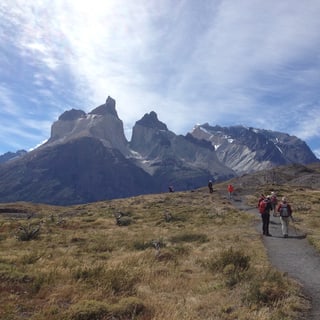Hikers following a path toward the mountains of Torres del Paine National Park